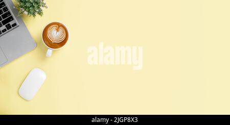 Office desk with laptop computer, mouse,  Cup of coffee on yellow background, Top view with copy space, Mock up. Stock Photo