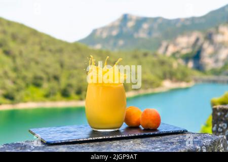 Splashing apricot juice with apricots on a tray Stock Photo