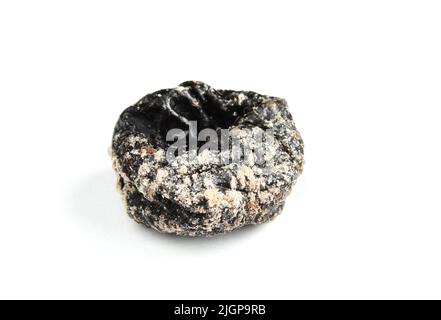 Single dried prune isolated on white background. Rotten moldy fruit close up Stock Photo