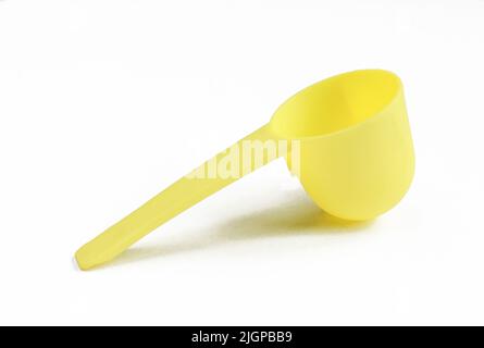 Empty measuring spoon isolated on white background. Deep yellow instrument Stock Photo