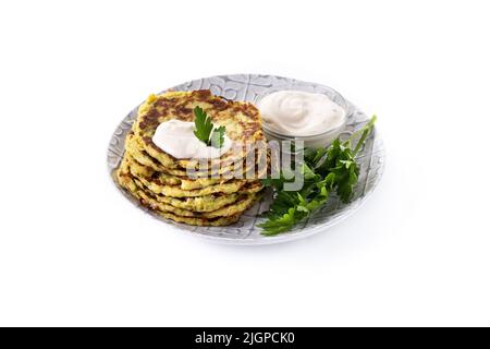 Zucchini fritters with yogurt sauce isolated on white background Stock Photo