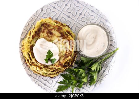 Zucchini fritters with yogurt sauce isolated on white background Stock Photo