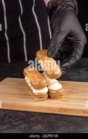 Making dessert tiramisu cake on a dark background in a coffee shop Stock Photo