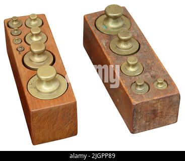 Set old vintage brass weights in wooden box isolated on white background Stock Photo