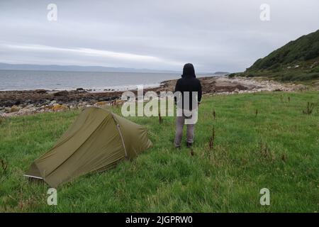 Solo Hiker wild camping in the Vango F10 Helium UL 1 Person Tent. Arran Coastal Way. Isle of Arran. North Ayrshire. Scotland. UK Stock Photo