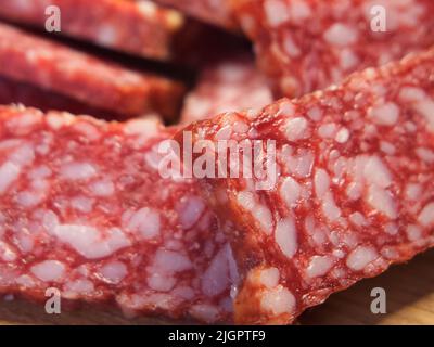Smoked sausage, full frame. Pieces of appetizing meat snack close-up. Salami Background Stock Photo