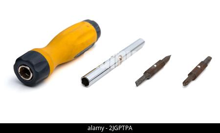 Bisassembled multi-bit screwdriver with replaceable bits on a white background. Close-up view of repair work tool. Selective focus on objects Stock Photo