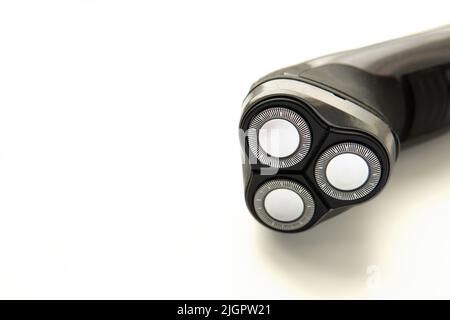 Men's electric rotary shaver isolated on white background. Close up photo of an electric razor laying sideways. Stock Photo