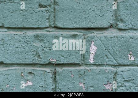 Old scratched and dirty brick wall painted with aquamarine color. Textured background of vintage brick wall. Panoramic view of empty wall, can be used for design. Stock Photo