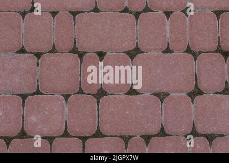 Road tiles of different sizes. Top view. The uneven pink color of the tile makes it look like a natural stone. Footpath. Urabism Stock Photo