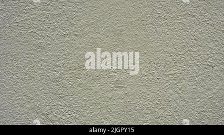 Pale yellow concrete wall. Interesting abstract background with a construction concept. Decorative textured plaster of the house wall. Outside surface finish at home. Stock Photo