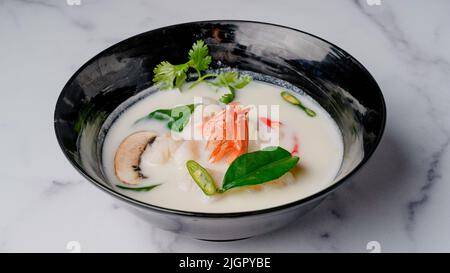 Kha coconut milk soup with shrimp. Traditional Chinese Thai restaurant soup close-up in a bowl Stock Photo