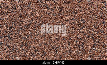 Multi-colored wall formed from small stones. Interesting abstract background pattern for your construction project. Individual outside surface finish at home. Decorative texture of the house wall.  Stock Photo