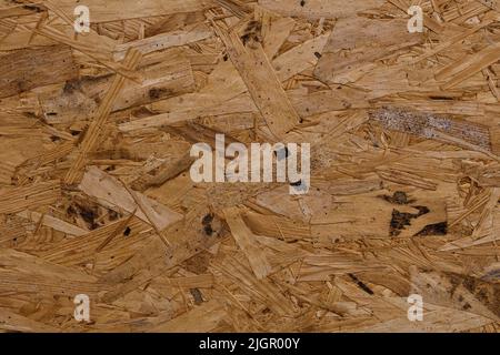 Oriented strand board OSB wallpaper. Abstract wooden background. The natural wood building material for finishing works. Waste woodworking. Wood texture material. Stock Photo