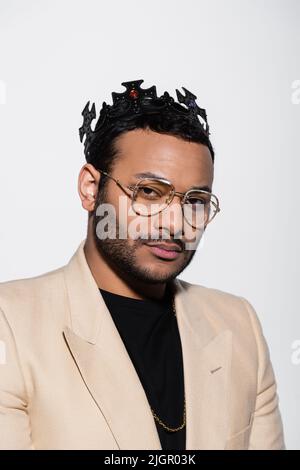 eastern hip hop performer in crown and eyeglasses isolated on grey Stock Photo