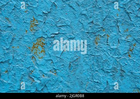 Old blue colored cracked paint. Paint applied to a rusty metal sheet. Grunge wall texture for your design. Old paint texture is chipping. Colored cracked abstract background.  Stock Photo