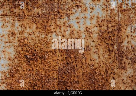 The rusty metal fence is covered with pimples. The aging process of iron. Metal oxidizes and corrodes. Process of degradation and decomposition. Rusty background. Rust texture Stock Photo