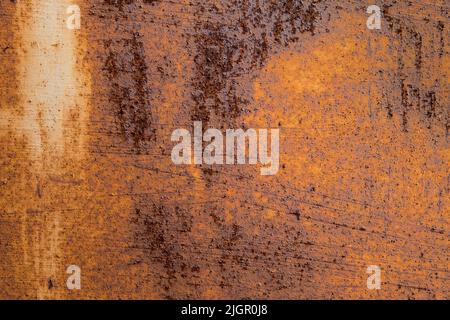 Rusty metal surface. The aging process of iron. Oxidation and corrosion. Degradation and decomposition. Damage over time. Orange abstract background. Stock Photo
