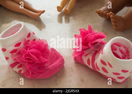 Baby socks with roses and legs dolls Stock Photo