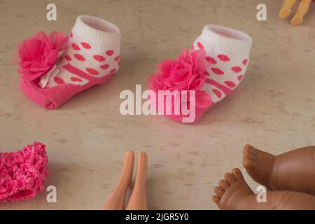 Pink polka dot baby socks and legs of dolls Stock Photo