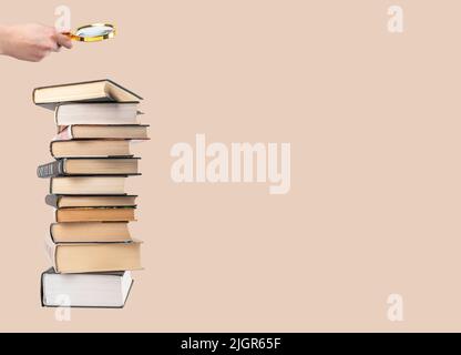 Banner with hand holding magnifying glass over books stack. Information search and analysis, research conducting. Data study for preparing for exams. Student lifestyle concept. Copy space. photo Stock Photo