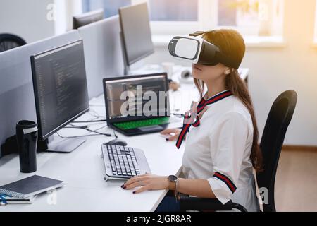Female professional using vr virtual reality headset at desk in office Stock Photo
