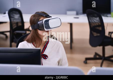 Female professional using vr virtual reality headset at desk in office Stock Photo