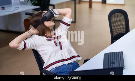 Female professional using vr virtual reality headset at desk in office Stock Photo