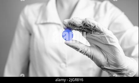 Doctors prescription concept. Hand holding round circle blue pill, tablet. High quality photo Stock Photo