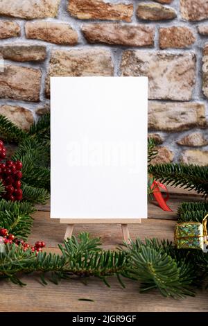 Christmas vertical card mockup template with fir twigs and Christmas decoration on wooden background. Design element for Christmas and New Year congra Stock Photo