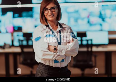 Portrait of female security operator while working in a data system control room offices Technical Operator Working at workstation with multiple Stock Photo