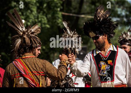 Kahnawake, Canada. 10th July, 2022. Pow-wow participants congratulate each other after a presentation. The 30th Annual Echoes of a Proud Nation pow-wow brought in thousands of people from all across North America to celebrate Native people culture and traditions in the Mohawk Reserve of Kahnawake. After a two-year hiatus, the biggest pow-wow in Quebec offered a time to meet, dance, sing, visit and celebrate with friends and family. (Photo by Giordanno Brumas/SOPA Images/Sipa USA) Credit: Sipa USA/Alamy Live News Stock Photo