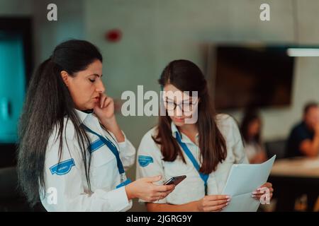 Group of female security operators working in a data system control room Technical Operators Working at workstation with multiple displays, security Stock Photo