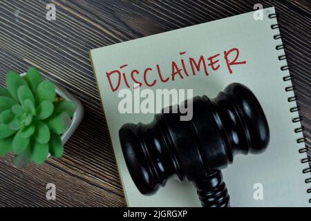 Concept of Disclaimer write on a book isolated on Wooden Table. Stock Photo