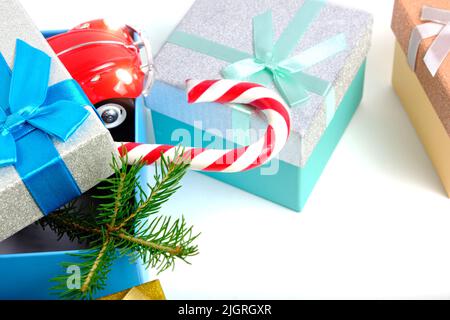Christmas gift boxes with gifts, with green Christmas tree and caramel on white background Stock Photo
