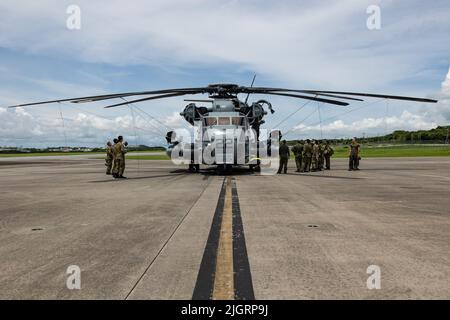 U.S. Marines assigned to Marine Heavy Helicopter Squadron (HMH) 361 brief the capabilities of a CH-53E Super Stallion helicopter to members of the Japan Ground Self Defense Force (JGSDF) 15th HELO Brigade at a static display on Marine Corps Air Station Futenma, Okinawa, Japan, July 7, 2022. HMH-361 held this event in cooperation with members of the Japan Ground Self Defense Force to deepen ties between forces and increase our allies' understanding of 1st Marine Aircraft Wing’s capabilities. Stock Photo