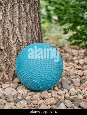 heavy rubber slam ball filled with sand on a backyard, exercise and functional fitness concept Stock Photo