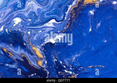 Luxury fluid art painting background. Spilled blue, white and gold acrylic paint. Liquid marble. Stock Photo