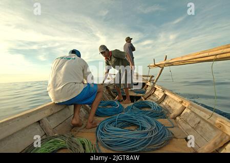 Whale hunters on traditional whaling boat equipped with bamboo harpoons and ropes, that is sailing on Savu Sea off the coast of Lamalera in Wulandoni, Lembata, East Nusa Tenggara, Indonesia. Stock Photo