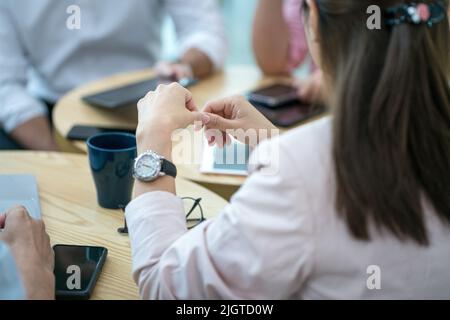 Business people having a meeting around a table.Close up view. Selected focus on woman executive's hands. Stock Photo