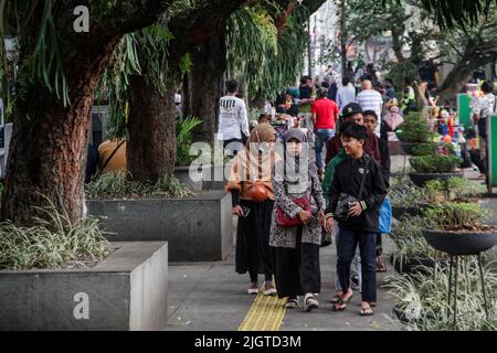 Bandung, West Java, Indonesia. 13th July, 2022. People who do not wear protective masks are seen walking in a shopping area in Bandung. Indonesian President Joko Widodo asked the public to wear masks both indoors and outdoors, this is related to the increasing spread of the Covid-19 virus in Indonesia. Travel policies have also been tightened, such as the mandatory requirements for booster vaccines to travel, entering a number of public facilities, offices, tourist attractions, to malls or shopping centers. (Credit Image: © Algi Febri Sugita/ZUMA Press Wire) Stock Photo