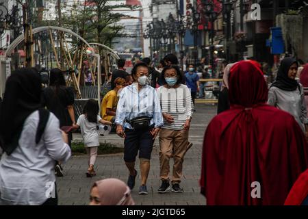 Bandung, West Java, Indonesia. 13th July, 2022. Women wearing a protective mask is seen walking in a shopping area in Bandung. Indonesian President Joko Widodo asked the public to wear masks both indoors and outdoors, this is related to the increasing spread of the Covid-19 virus in Indonesia. Travel policies have also been tightened, such as the mandatory requirements for booster vaccines to travel, entering a number of public facilities, offices, tourist attractions, to malls or shopping centers. (Credit Image: © Algi Febri Sugita/ZUMA Press Wire) Stock Photo