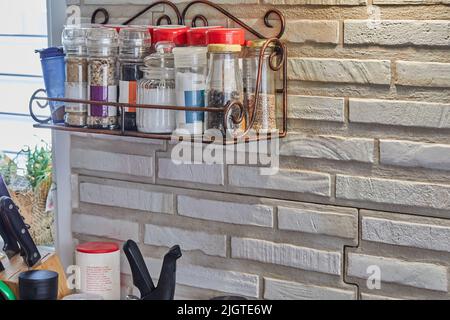 Brick wall with shelf and spices in the kitchen Stock Photo