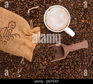 Lay flat, coffee beans poured out of bag with ascoop and a cup of coffee Stock Photo