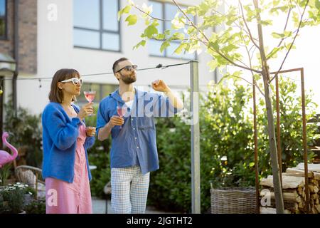 Stylish couple have a drink at the backyard Stock Photo
