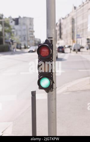 Green traffic light on a blurred buildings background Stock Photo