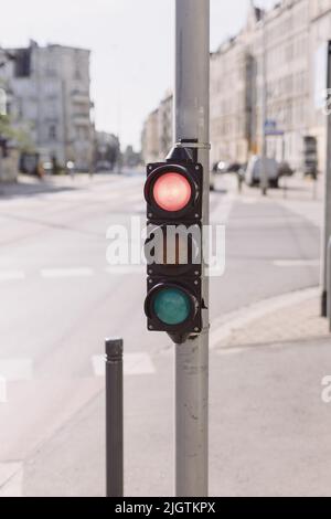 Red traffic light on a blurred buildings background Stock Photo
