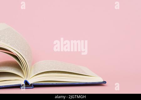 Open book page closeup on pink background, back to school education concept Stock Photo