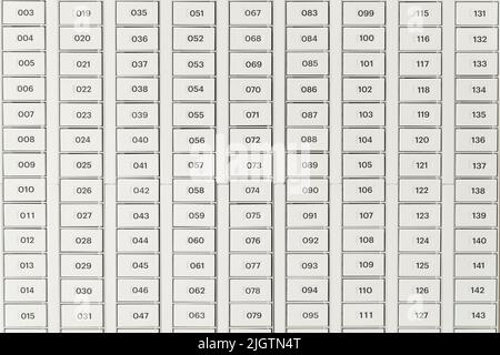 Mailboxes for letters and correspondence. Modern white mailboxes with numbers in the lobby of a residential or office building. High quality photo Stock Photo