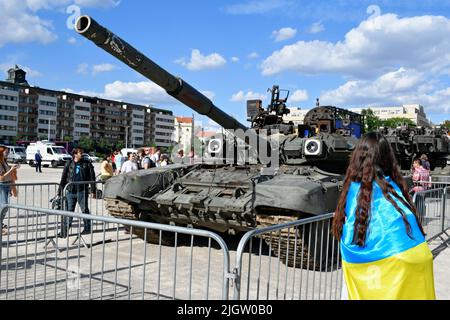 Ukraine girl with flag on exhibition of disabled russian military equipment in ukraine - russian war in Prague. Stock Photo